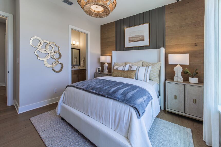 Bedroom with a wood accent wall and a white upholstered bed