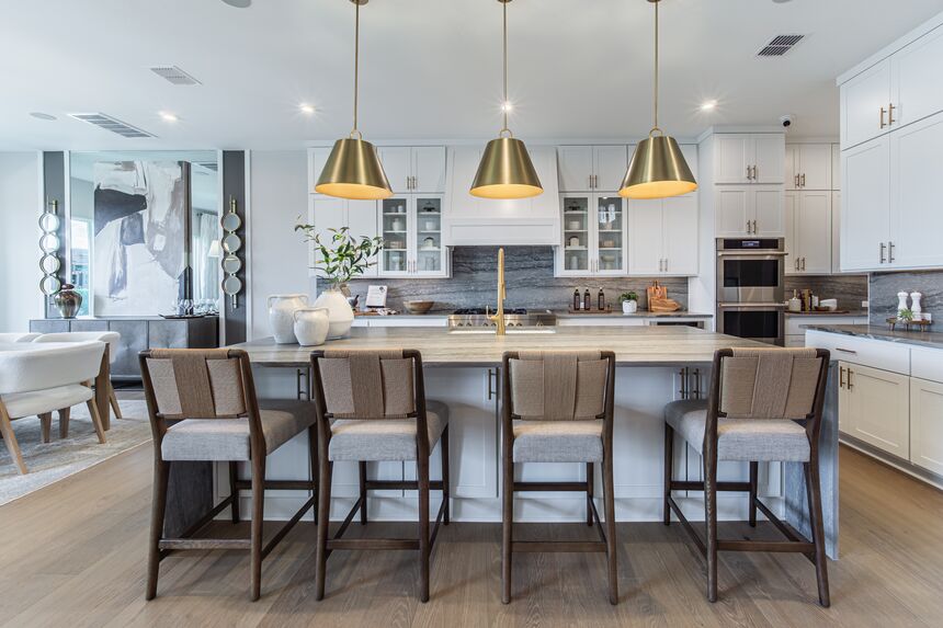 Kitchen island with four bar stools and brass pendant lights